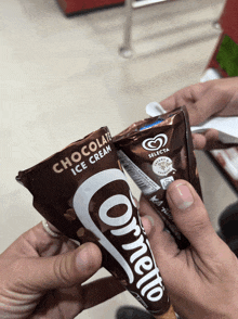 a person holding a chocolate ice cream cone