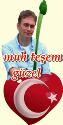 a man in a blue shirt is holding a green flower in front of a red heart that says muhteşem guzel