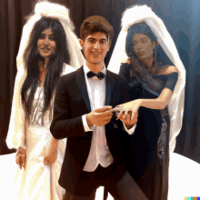 a man in a tuxedo and bow tie stands between two women in wedding dresses