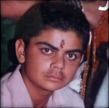 a close up of a young man 's face with a piercing in his forehead