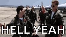 a group of men in military uniforms are standing on a runway with the words hell yeah written in white