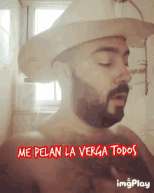 a shirtless man with a beard wearing a cowboy hat with the words me pelan la verga todos below him