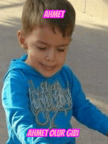 a young boy wearing a blue shirt that says ahmet