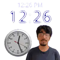 a man with glasses stands in front of a clock that reads 12:26 pm