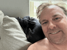 a shirtless man laying on a couch with a dog