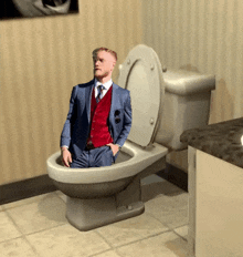 a man in a suit sits on a toilet