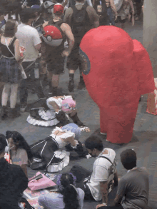 a group of people are gathered around a red among us character