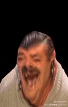 a man with a mustache is laughing with his mouth open and his tongue out .