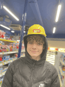 a boy wearing a black nike jacket and a yellow helmet with the word boss on it