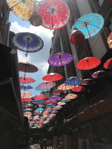 a row of colorful umbrellas hanging from a building