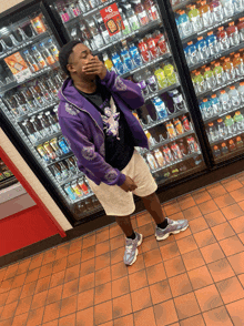 a man in a purple jacket is standing in front of a vending machine that says gatorade