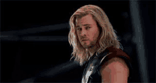 a close up of a man with long hair and a beard .