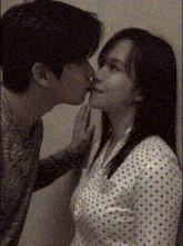 a man is kissing a woman on the forehead in a black and white photo