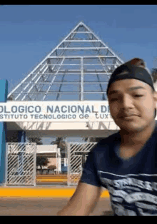 a man is taking a picture in front of a building that says instituto tecnologico de tux .