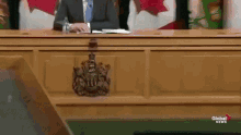 a man in a suit and tie is sitting at a desk in front of a podium that says global news