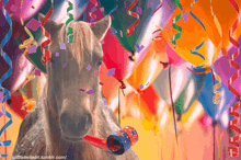 a horse holding a party horn in front of balloons