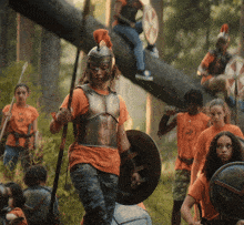 a group of children are dressed up as roman soldiers and one of them is wearing a helmet with a crest on it