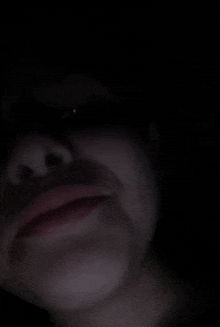 a close up of a person 's face in a dark room