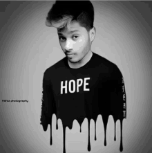 a black and white photo of a young man wearing a hope shirt