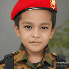 a young boy wearing a red beret and military uniform