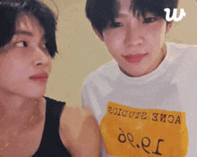 two young men are looking at each other and one of them is wearing a shirt that says de.e.s.