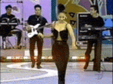a woman is dancing on a stage while a man plays guitar