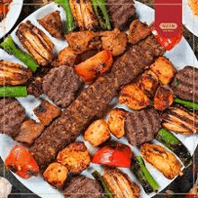 a white plate topped with a variety of meats , vegetables and shish kebabs .