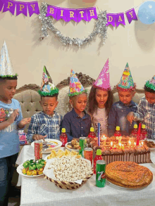 a happy birthday banner hangs above a table full of food