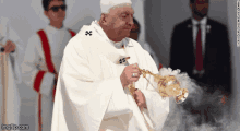 a man in a white robe is holding a saxophone with a watermark that says imgflip.com on it