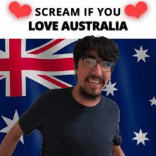 a man with glasses is smiling in front of an australian flag and a sign that says scream if you love australia