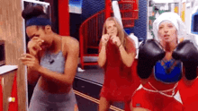a group of women are standing next to each other wearing boxing gloves in a room .
