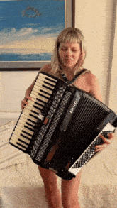 a naked woman is playing an accordion that says bello on it