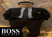 a man in a suit and tie is standing in front of a sign that says boss hugo boss