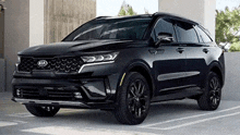 a black kia sorento suv is parked in a parking lot .