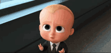 a baby is wearing a suit and tie and making a face