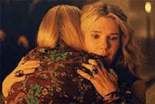 two women are hugging each other in a room .