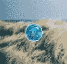 a pixel art illustration of a blue ball on a sandy beach .