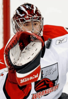 a goalie wearing a las vegas wranglers jersey holds his glove up