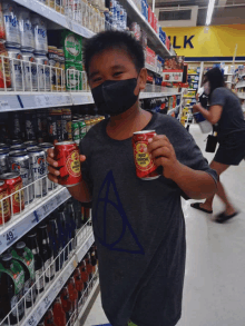 a boy wearing a mask is holding two cans of red monkey beer