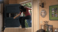 a woman is jumping on a couch in front of a door