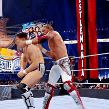 two men are wrestling in a ring with a sign that says ' wrestlemania ' on it