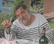 a man is sitting at a table with a birthday cake and candles