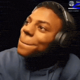 a man wearing headphones is making a funny face while looking at the camera .
