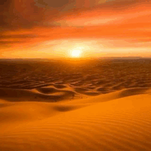 the sun is setting over a desert landscape with sand dunes .