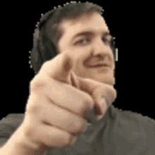 a man wearing headphones is giving a thumbs up sign .