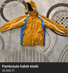 a yellow and blue jacket is sitting on a rug and the price is 20 000 ft