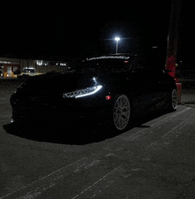 a black car with the word mcdonalds on the windshield is parked in a parking lot at night