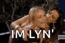 a couple of women standing next to each other with the words `` im lyn '' on the bottom .