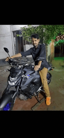 a man is sitting on a yamaha motorcycle in front of a building .