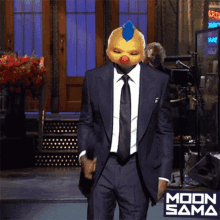 a man in a suit and tie is wearing a clown mask with a blue feather on it